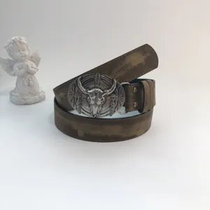 Detailed view of women's western vintage leather belt with metal bull skull buckle accessory.