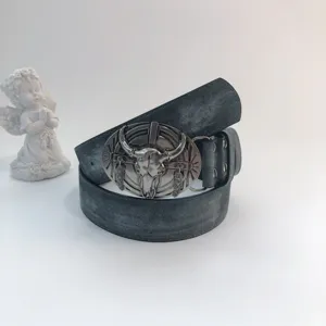 Vintage western cowboy leather belt detail showcasing a detailed bull skull metal buckle.