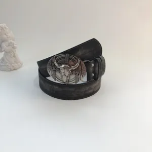 Western vintage leather belt with metallic bull skull buckle for women denim jeans outfit.