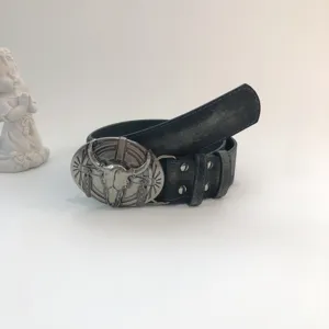 Western vintage style women leather belt detail showing unique metal bull skull buckle design.