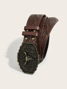 Closeup of western brown PU leather belt featuring floral embossing and bull skull buckle.