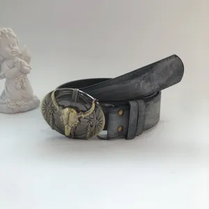 Vintage western style distressed leather belt featuring metal bull skull buckle design