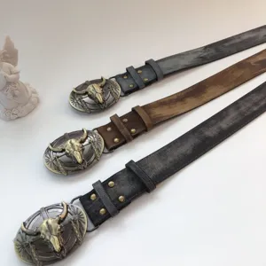 Detail view of vintage women's leather belt featuring retro metal bull skull buckle and distressed finish.