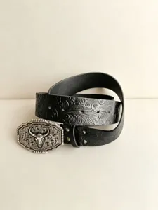 Vue detaille de la ceinture en faux cuir noir style western avec boucle tete de taureau.