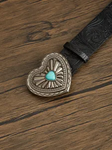 Detailed close-up of a women vintage western black leather belt with ornate heart buckle.