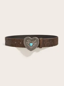 Close-up detail of vintage brown embossed leather belt with ornate silver heart buckle.