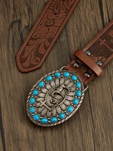 Close-up of western leather belt with turquoise stone buckle and embossed floral pattern.