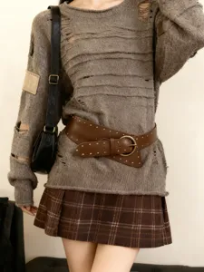Détail de ceinture large cloutée punk, accessoire de taille en cuir marron, design rétro élégant.