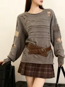 Gros plan détaillé de la ceinture large cloutée de style punk avec une boucle ronde en métal.