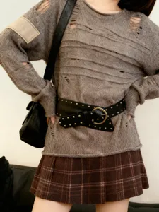 Vue détaillée de la ceinture large noire style punk avec rivets métalliques et boucle ronde.