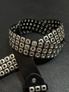 Punk rock style black leather belt with multiple rows of metal eyelets and rivets detail.
