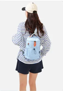 Detailed view of a stylish light blue multi-functional mini backpack worn by model outdoors.