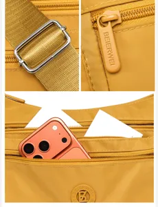 Detailansicht der gelben Nylontasche mit Metallbeschlägen, Reißverschlüssen und Fächern.