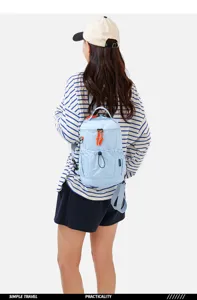 Backpack worn by model showing casual travel design with front pocket and blue color scheme.