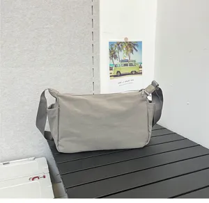 Detailaufnahme der grauen Nylontasche mit breitem Gurt und Seitentaschen für den Alltag.