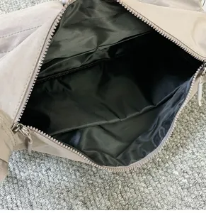 Nylon Umhängetasche Innendetail mit schwarzem Futter, Reißverschluss und sicheren Innentaschen.