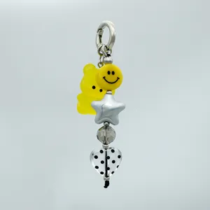 Primo piano dettagliato del ciondolo carino con orsetto giallo, stella e perla a cuore.