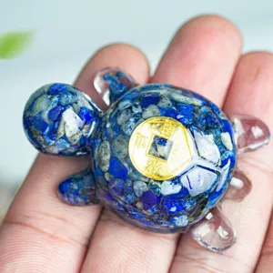 Détail de la tortue en résine de cristal avec de fins éclats de lapis-lazuli et une pièce dorée.