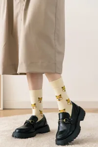 Gros plan de chaussettes montantes à jacquard de chien mignon avec des mocassins noirs.
