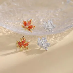 Pendientes de tuerca de circonita con hoja de arce, brillantes cristales naranjas y plateados.