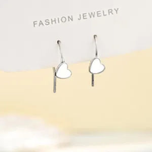 Primer plano detallado de pendientes colgantes de corazón plateado, joyería de moda.