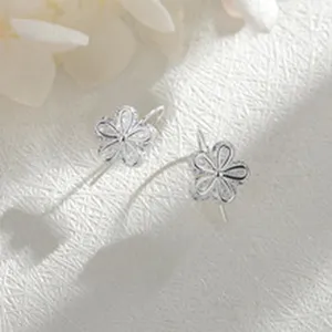 Vista detallada de exquisitos pendientes colgantes de plata con diseño floral en fondo blanco.