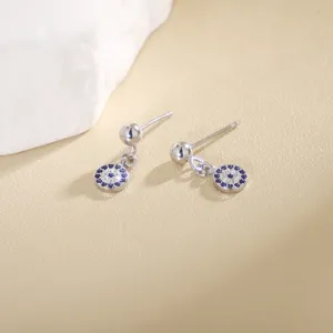 Detalle en primer plano de pendientes colgantes de mal de ojo de circonita azul y blanca con perno.