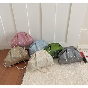 Gros plan de sacs clutch métalliques élégants avec des perles et de belles chaînes.
