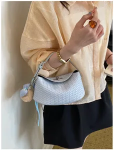 Light blue woven leather shoulder bag with chic metal lock closure and cute fluffy bow pendant detail.