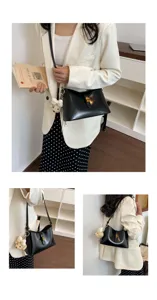 Detailed view of the black leather shoulder bag featuring a gold buckle and cute plush charm.