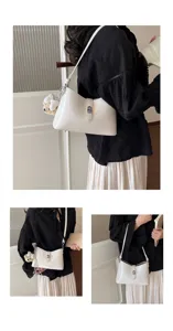 Close-up detail of the elegant white shoulder bag featuring fine metal turn-lock hardware.