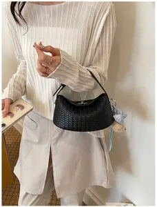 Detailed shot of a chic black woven handbag featuring an intrecciato design and metal lock.