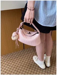 Pink woven shoulder bag detail, stylish underarm purse with cute plush charm and metal lock.