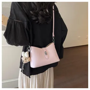 Stylish pink shoulder bag with metal lock and cute bear pendant for daily commuting.
