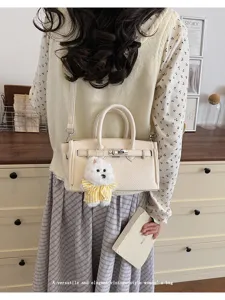 Elegant vintage-style women's shoulder bag with chic litchi grain and cute dog pendant.