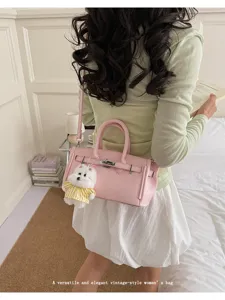Detailed view of stylish women pink lychee grain faux leather top handle kelly bag