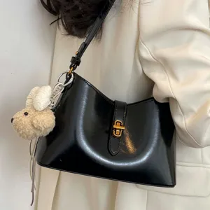 Stylish black patent leather underarm shoulder bag for women, chic commuting crossbody bag.