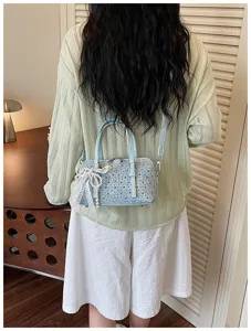 Denim patchwork bowling bag with studs and pearl bow detail for women versatile crossbody.