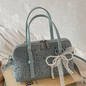 Chic denim bowling handbag with stylish studs and elegant lace pearl bow decoration.