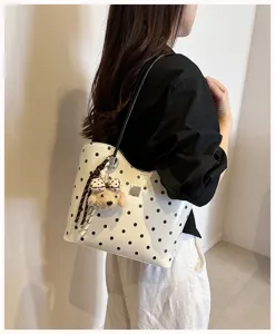 Detailed view of women polka dot shoulder bag with cute puppy plush charm for daily use.