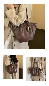 Detailopname van de grote bruine retro shopper tas met decoratieve kralenhangers.