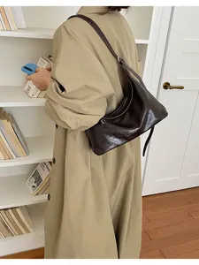Λεπτομερής φωτογραφία σκούρας καφέ λουστρίνι γυναικείας τσάντας ώμου σε ρετρό στιλ.