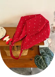 Vista detallada del bolso de lona floral roja con bonito colgante de manzana y gran capacidad.