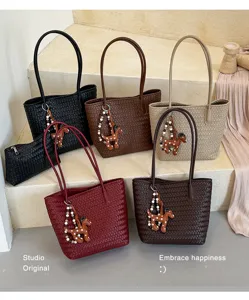 Woven tote shoulder bag for women, stylish commuting handbag with cute dog charm, vintage design.
