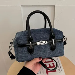 Denim boston shoulder bag for women, stylish leather trim pillow handbag with metal lock hardware.