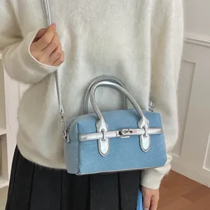 Blue denim Boston shoulder bag for women, stylish metallic silver handles and crossbody strap.