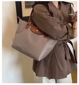 Detailed view of the stylish nylon shoulder tote bag featuring classic brown leather handles.