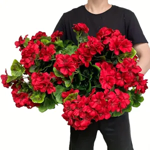 Detailed view of vibrant red artificial geranium bouquet with green leaves for home decor.