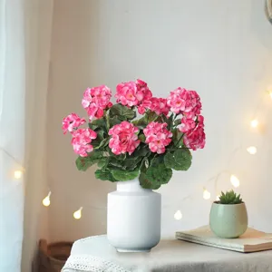 Detailed view of artificial pink geranium flower bouquet in white ceramic vase for home decor.