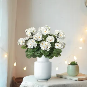 Detail view of white artificial geranium bouquet in ceramic vase for home decor and cozy styling.